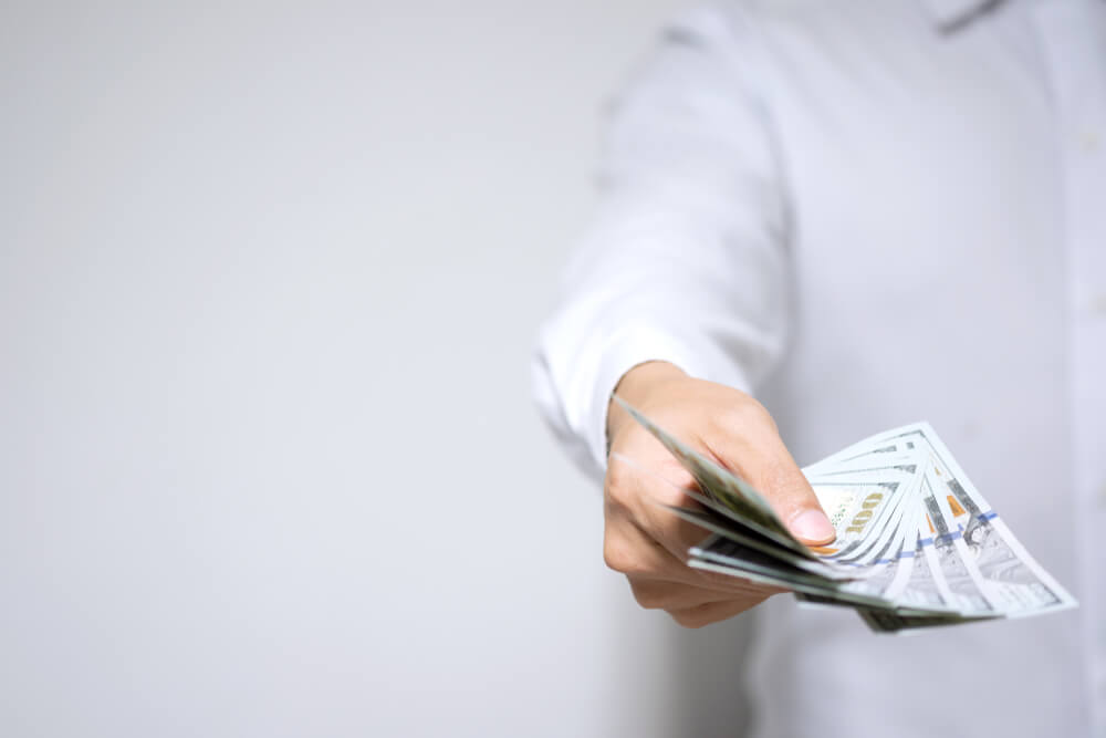 mężczyzna podaje pieniądze